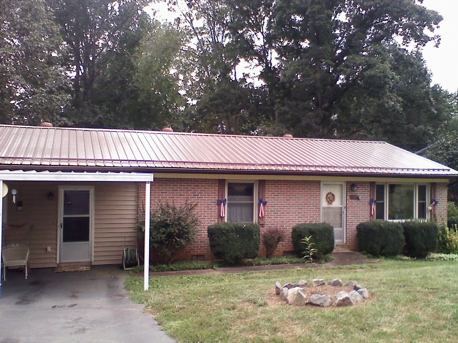 Bronze metal roof and carport on a brick ranch home — Roof Repair work by our crew in Greenville